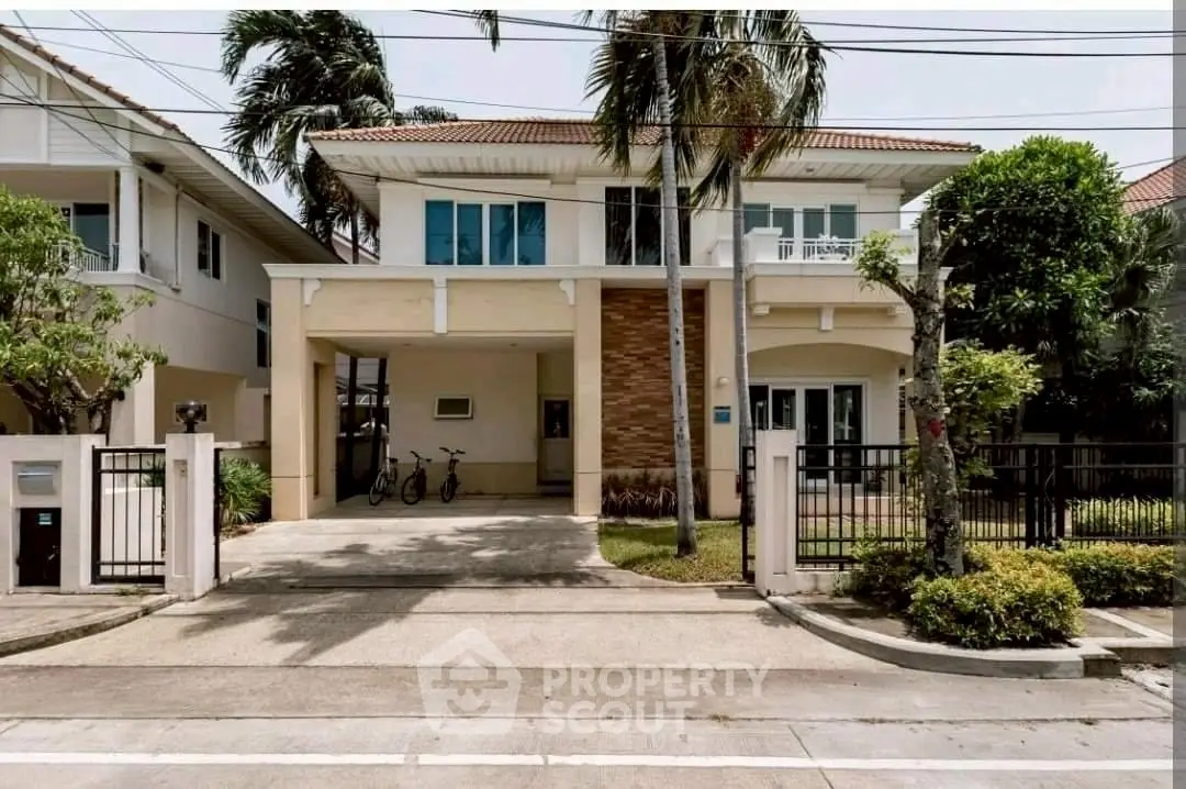 Charming two-story house with spacious driveway and lush greenery in a serene neighborhood.