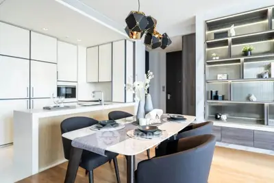 Modern dining area with elegant table setting and stylish kitchen in open layout apartment.