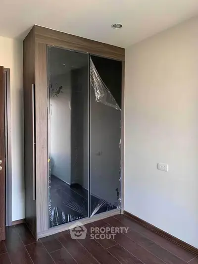 Modern bedroom with sleek built-in wardrobe and wooden flooring