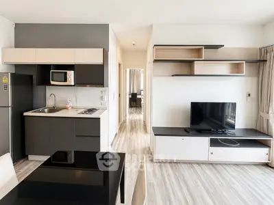 Modern open-plan living room with sleek kitchen and stylish shelving, perfect for contemporary living.