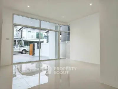 Spacious modern living room with large windows and glossy tile flooring