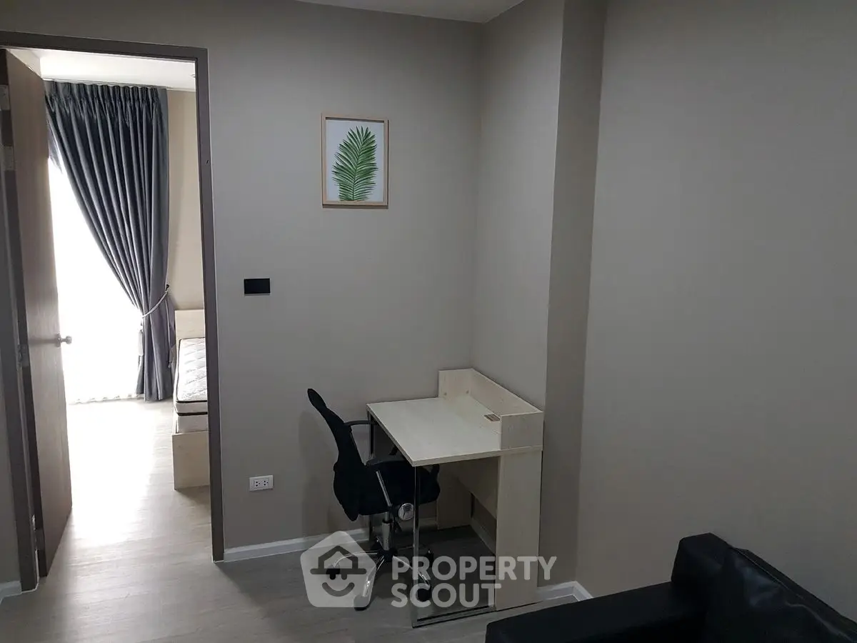 Modern study area with desk and chair in a stylish apartment, featuring neutral tones and sleek design.