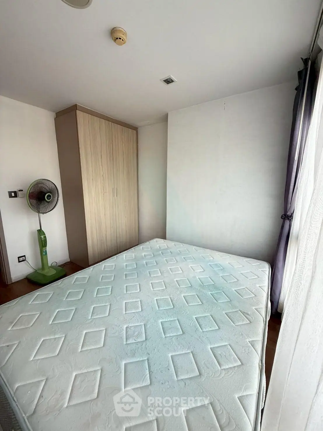 Spacious bedroom with large window and wardrobe, perfect for natural light lovers.