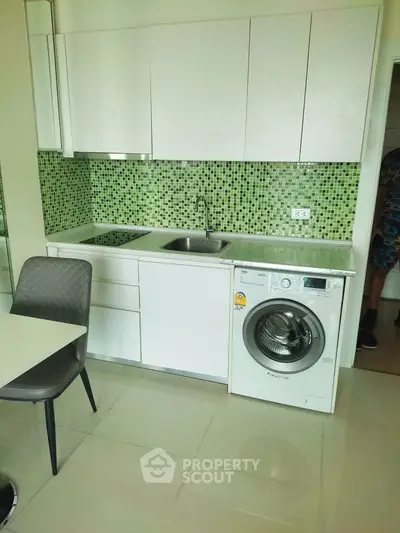 Modern kitchen with green mosaic backsplash and built-in washing machine