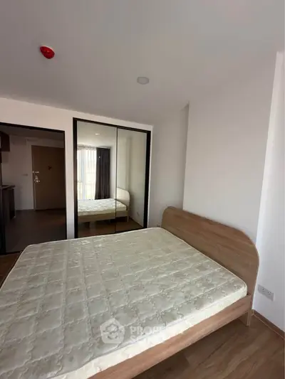 Modern bedroom with mirrored closet and wooden flooring in a stylish apartment.