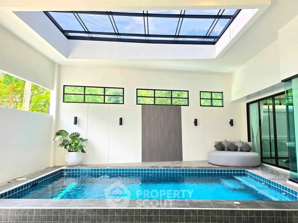 Luxurious indoor pool with skylight and modern design, perfect for relaxation and entertainment.