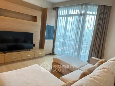 Spacious living room with modern furniture and large windows offering city views.