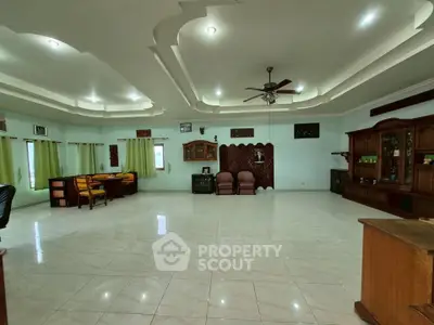 Spacious living room with elegant ceiling design and ample natural light.