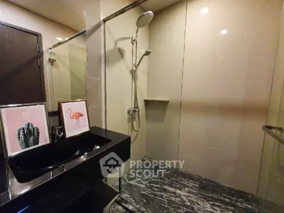 Modern bathroom with sleek black sink and stylish shower area