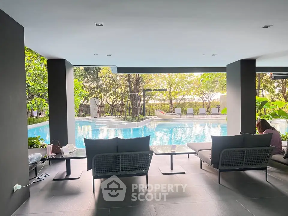 Luxurious poolside lounge area with modern seating and lush greenery