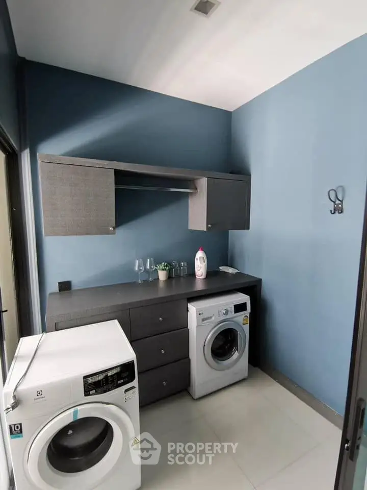 Modern laundry room with washing machines and sleek cabinetry
