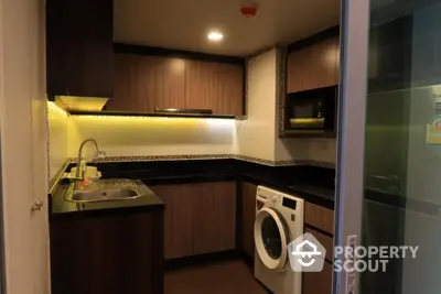 Modern kitchen with sleek cabinetry and built-in washing machine