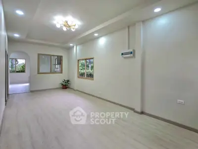Spacious modern living room with elegant lighting and large windows for natural light.