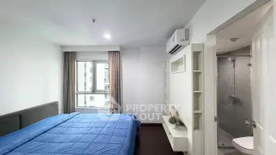 Modern bedroom with ensuite bathroom and large window in a stylish apartment.