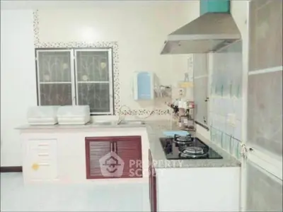 Spacious kitchen with modern gas stove and ample counter space