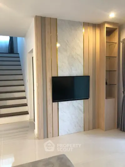 Modern living room with stylish TV wall and elegant staircase