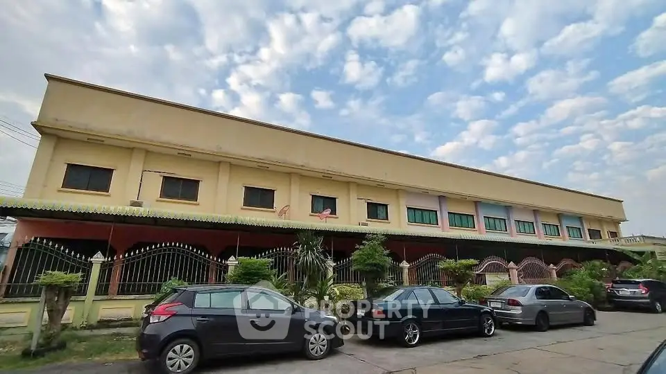 Spacious multi-unit building with ample parking and lush greenery, perfect for residential or commercial use.