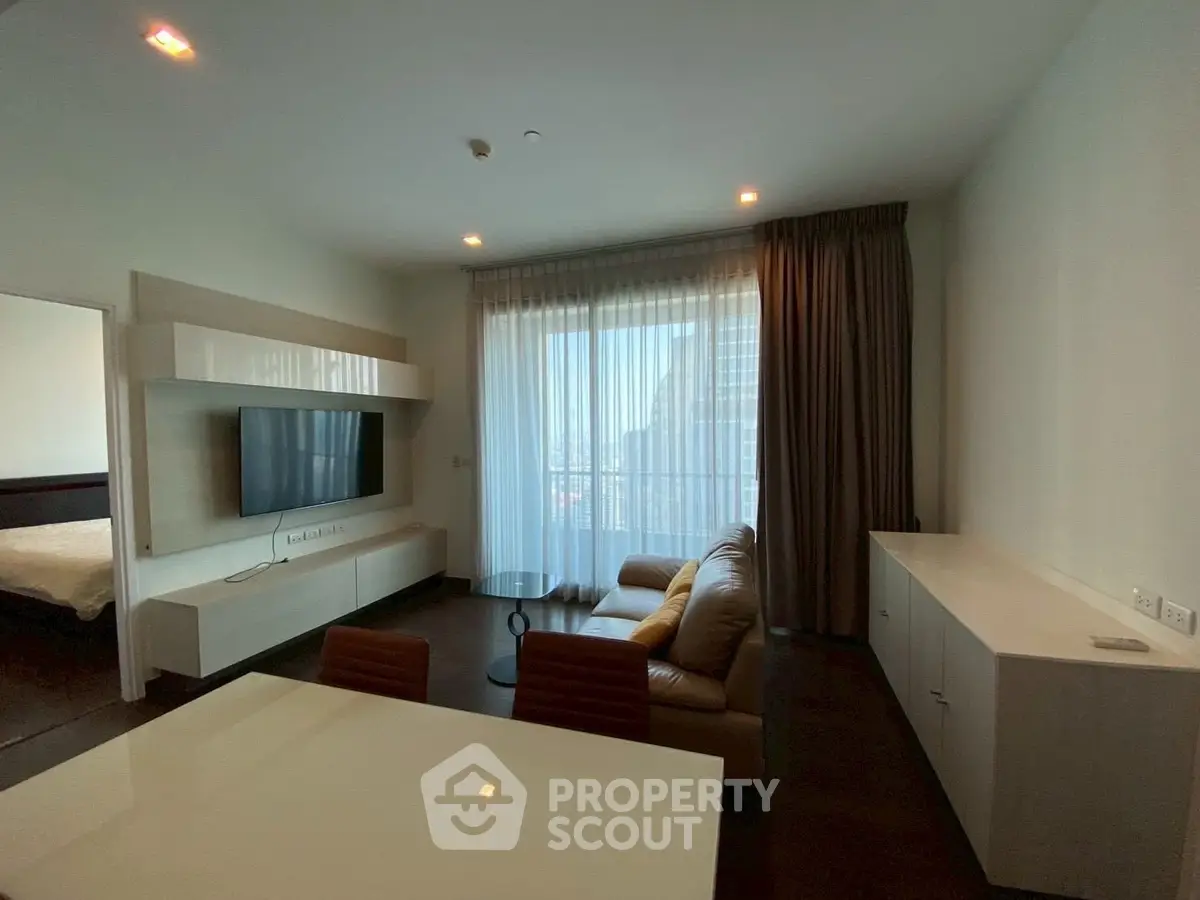 Modern living room with sleek furniture and large window offering natural light