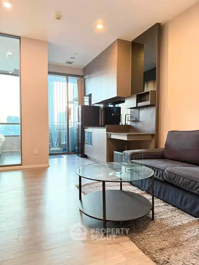 Modern living room with open kitchen and balcony view in urban apartment