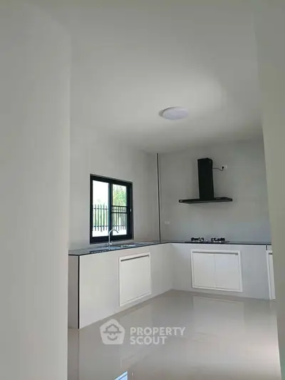 Modern kitchen with sleek white cabinetry and gas stove in a bright, minimalist design.