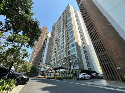 Modern high-rise condominium with lush landscaping and ample parking space.