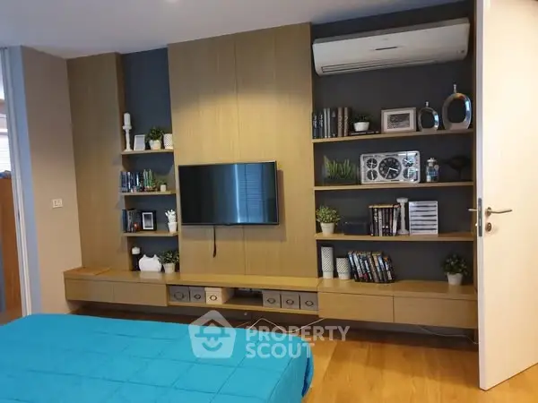 Modern bedroom with stylish shelving and wall-mounted TV