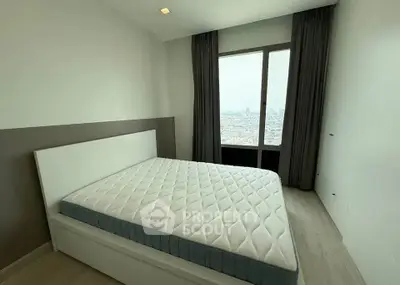 Spacious bedroom with large window offering stunning city views, modern design and ample natural light.