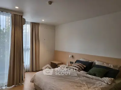 Cozy bedroom with natural light and modern decor in a stylish apartment.