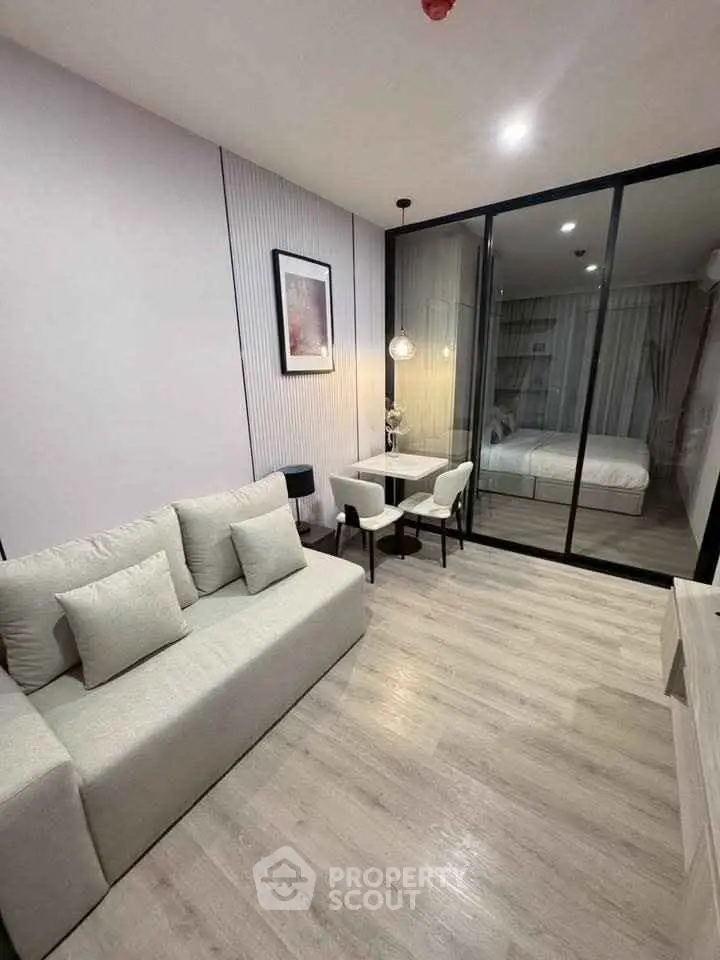 Modern living room with glass partition and cozy bedroom view