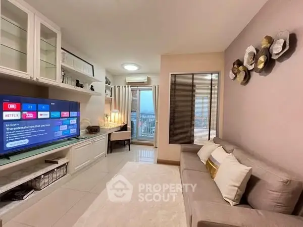 Modern living room with cozy sofa and entertainment setup, featuring stylish decor and natural light.