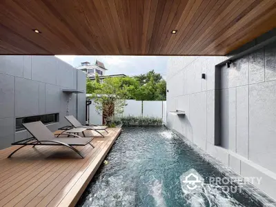 Luxurious private pool with modern deck and sun loungers in serene outdoor setting.