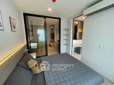 Modern bedroom with cozy decor and sliding glass doors leading to a stylish living area.