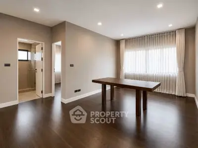 Spacious modern living room with elegant wooden flooring and natural light.