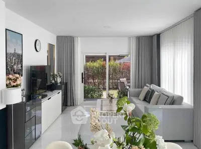 Modern living room with sleek design, large windows, and garden view, perfect for relaxation and entertainment.