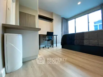 Modern bedroom with sleek desk and chair, large window, and stylish flooring.