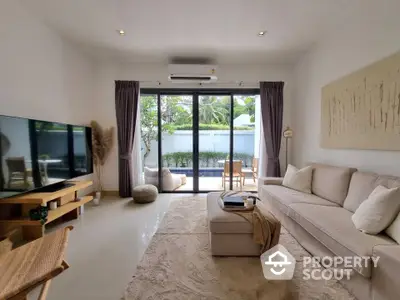 Spacious living room with modern decor and pool view, perfect for relaxation and entertainment.