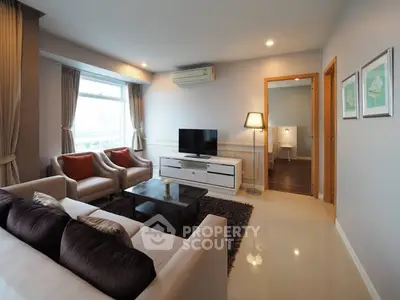 Modern living room with elegant decor and natural light, featuring comfortable seating and stylish furnishings.