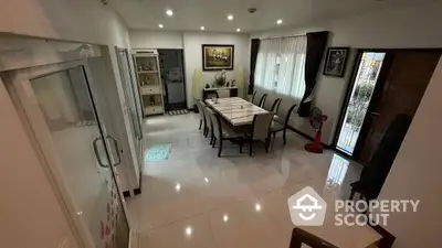 Spacious and elegantly furnished living room with gleaming tiled floors, large dining area, and ample natural light, perfect for family gatherings and entertaining guests.