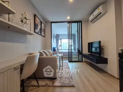 Modern living room with sleek design and open layout leading to a bedroom with city view.