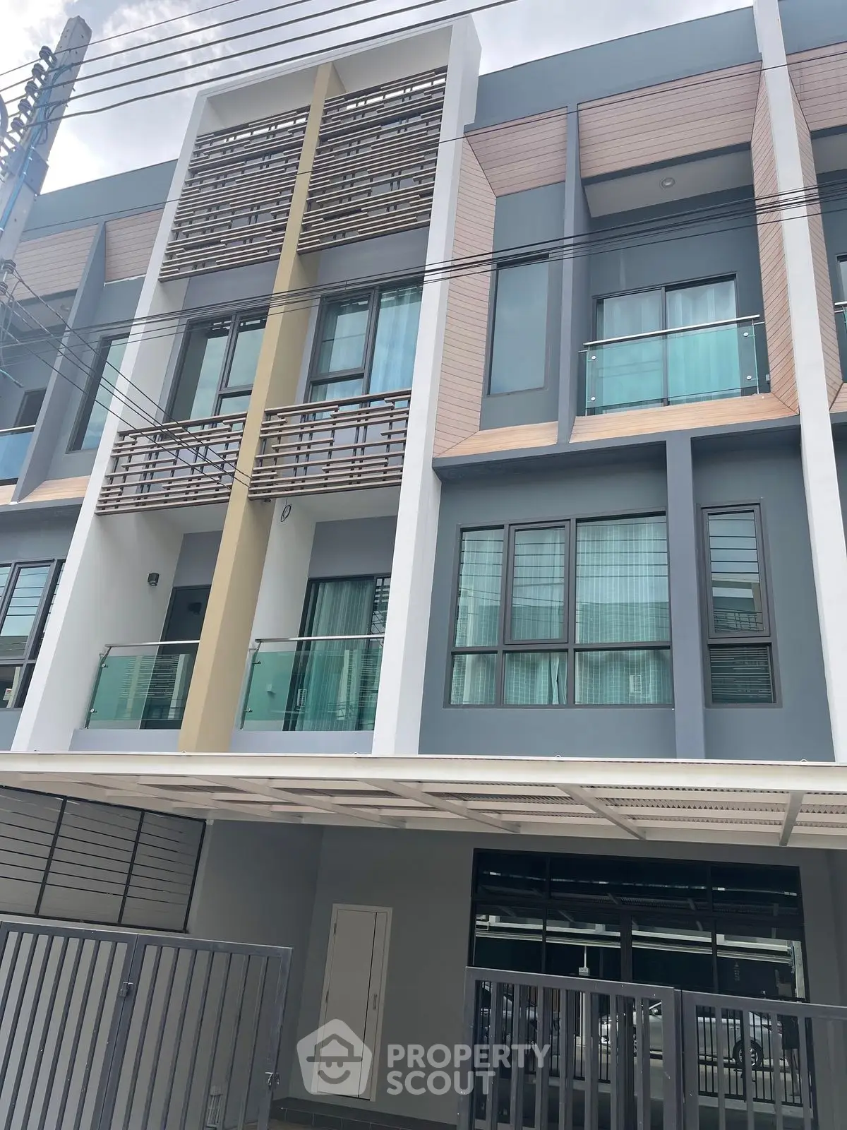 Modern multi-story townhouse with sleek facade and glass balconies.
