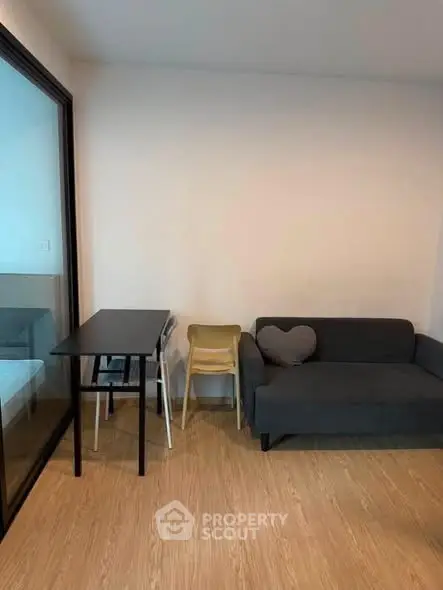 Modern living room with cozy sofa and dining table, featuring minimalist design and wooden flooring.