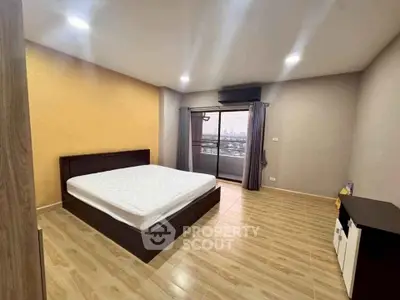 Spacious bedroom with balcony and city view in modern apartment