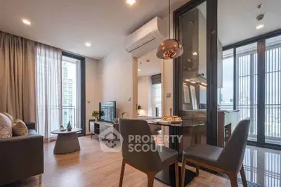 Modern open-plan living room with dining area and balcony view in a stylish apartment.