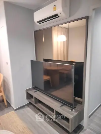 Modern living room with sleek TV setup and air conditioning unit