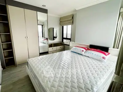 Spacious bedroom with modern decor and large windows offering natural light.