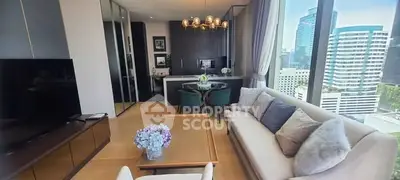 Modern living room with city view, elegant decor, and open kitchen layout.