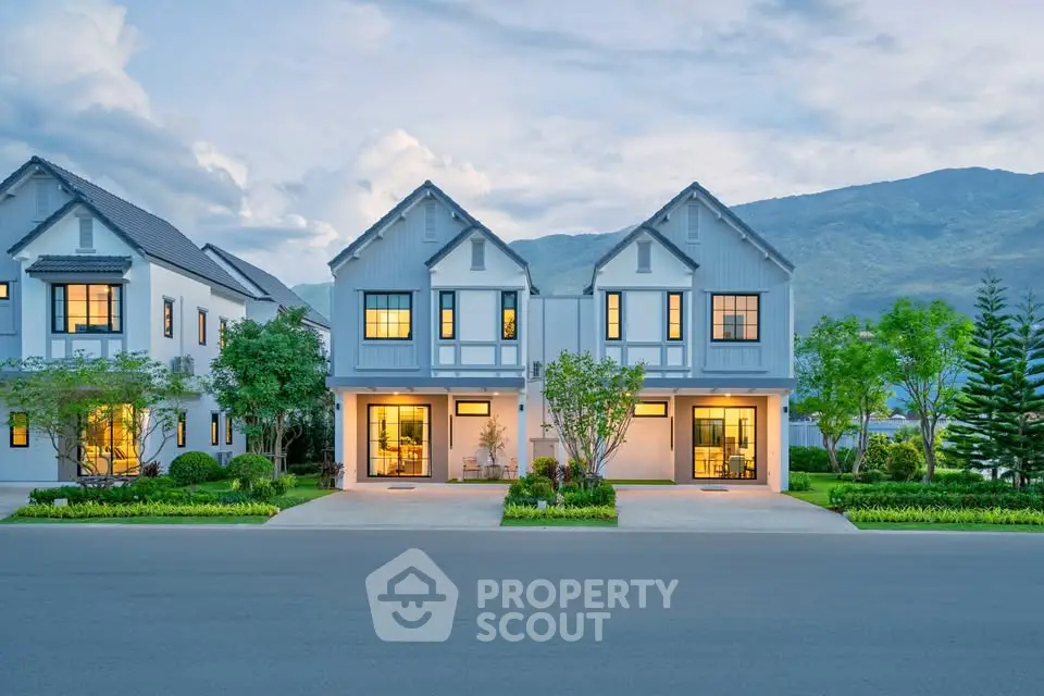 Charming modern duplex homes with scenic mountain backdrop and lush landscaping.