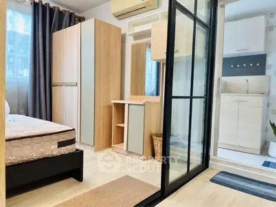 Modern bedroom with sliding glass door and compact kitchen area