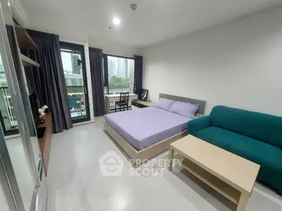 Modern studio apartment with balcony and city view, featuring cozy bed and stylish furniture.