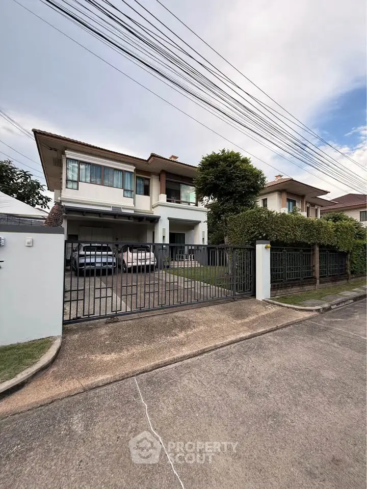 Charming two-story house with spacious driveway and lush greenery in a serene neighborhood.
